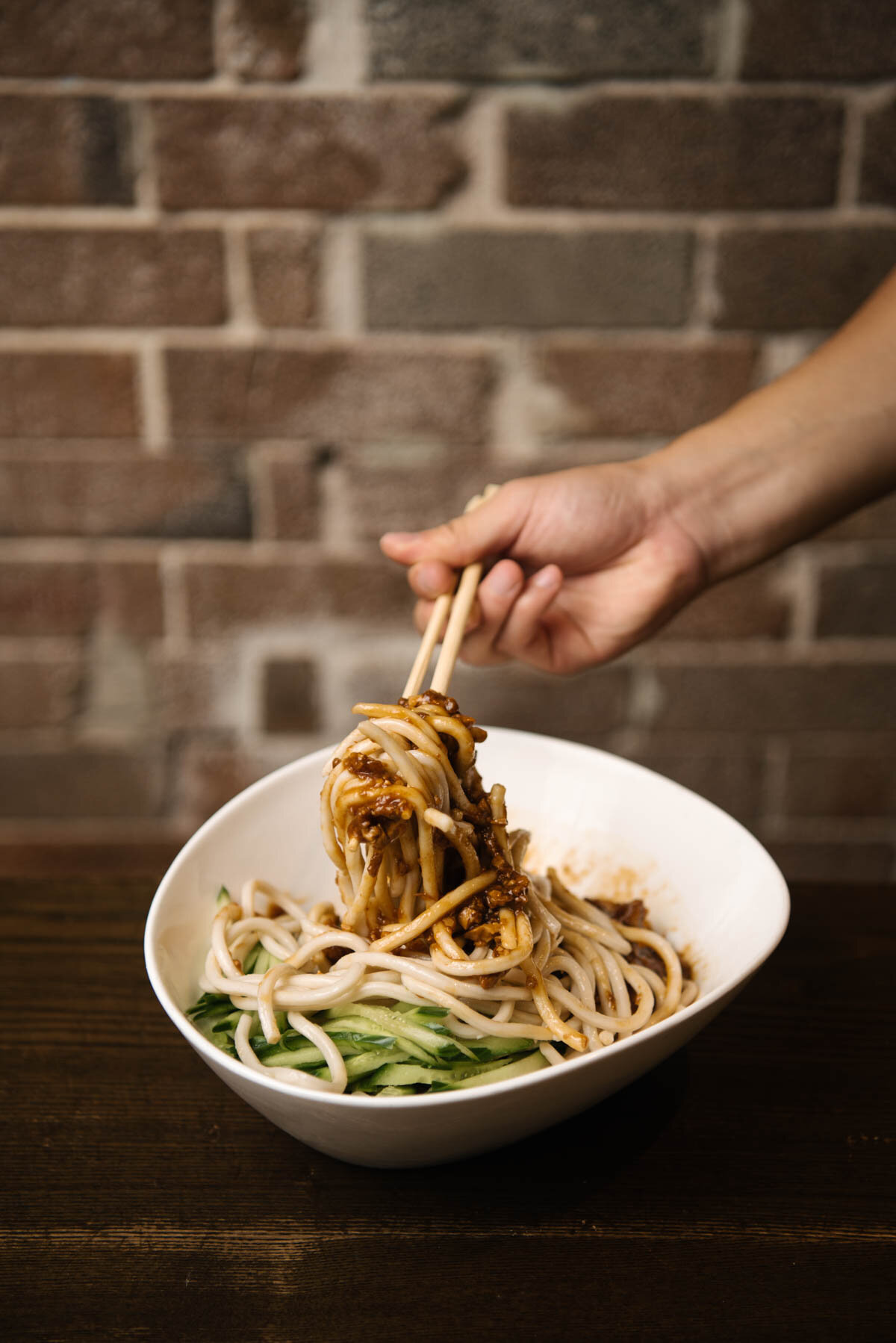 New Shanghai Ashfield 官网面食照片，筷子夹起碗中的面条
